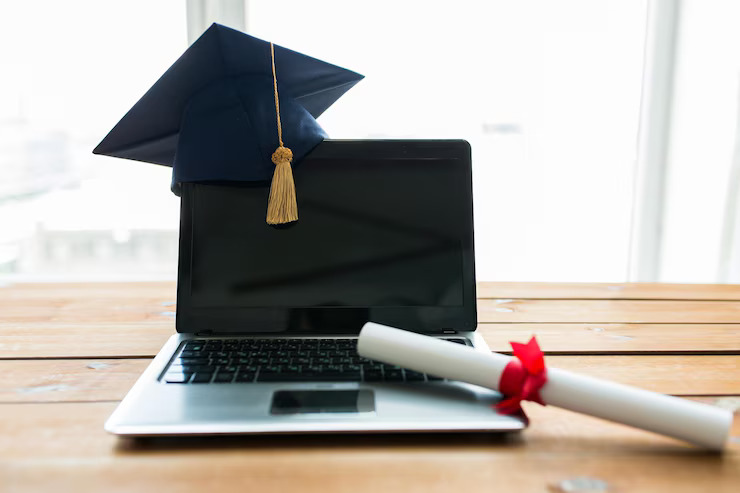 education-graduation-technology-e-learning-concept-close-up-laptop-computer-with-mortarboard-diploma-scroll-wooden-table_380164-132944